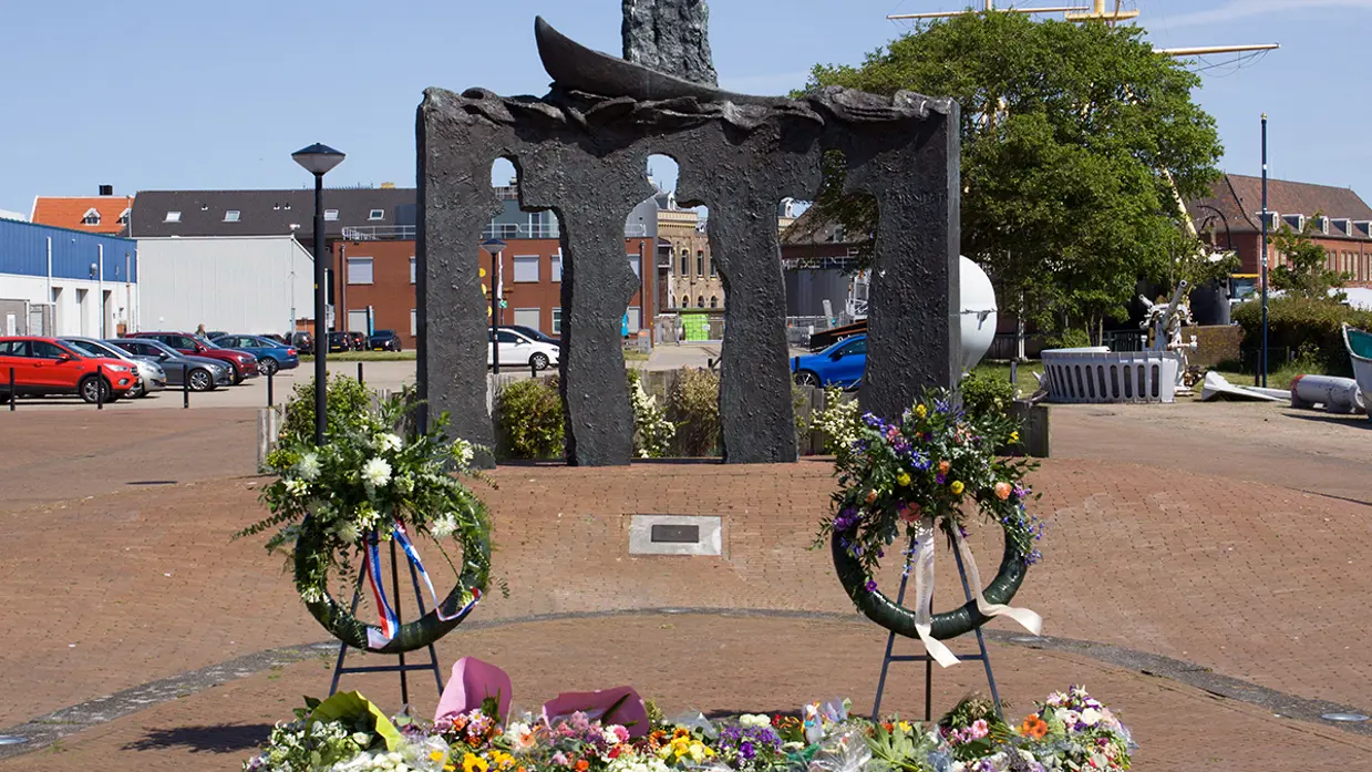 Het monument Schaduwen van het Licht met op de achtergrond de parkeerplaats van de marinewerf Willemsoord.