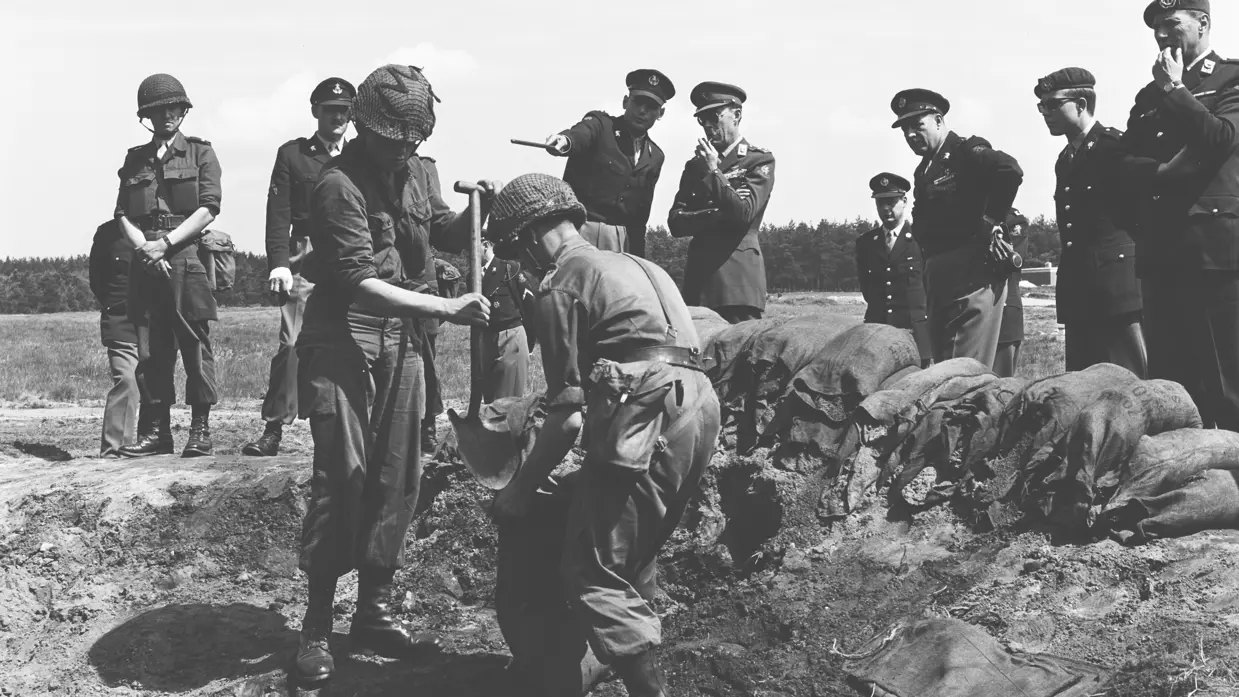 1965. Militairen vullen zakken met zand. Prins Bernhard inspecteert de genisten.