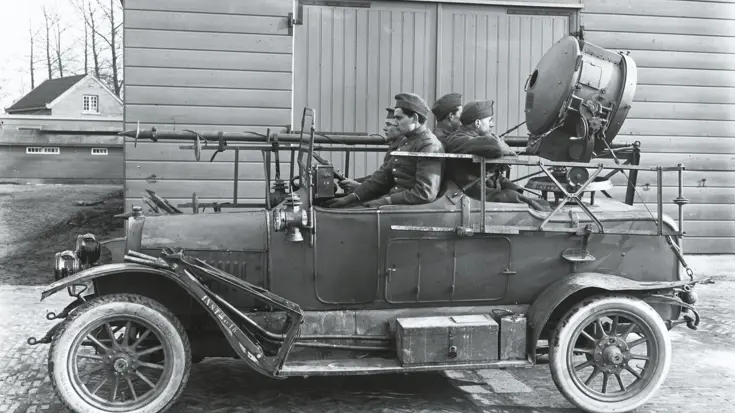 4 militairen zitten in een auto met een zoeklicht.