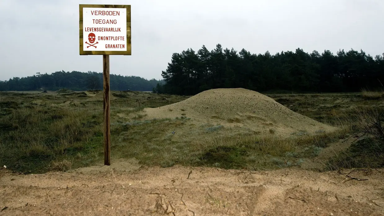 Bord op schietbanen en oefenterreinen met de tekst: verboden toegang, levensgevaarlijk, onontplofte granaten.