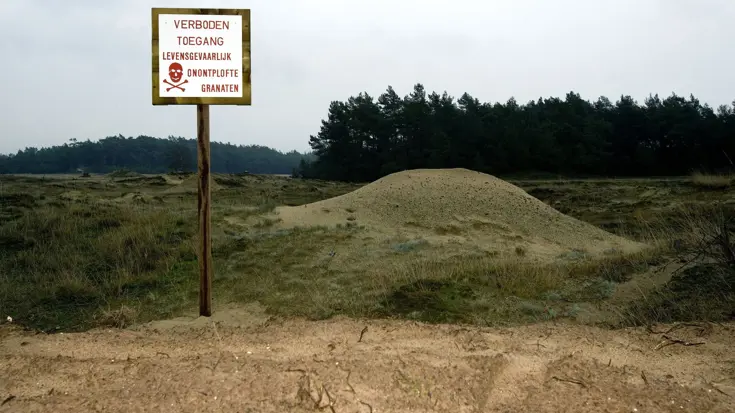 Bord op schietbanen en oefenterreinen met de tekst: verboden toegang, levensgevaarlijk, onontplofte granaten.