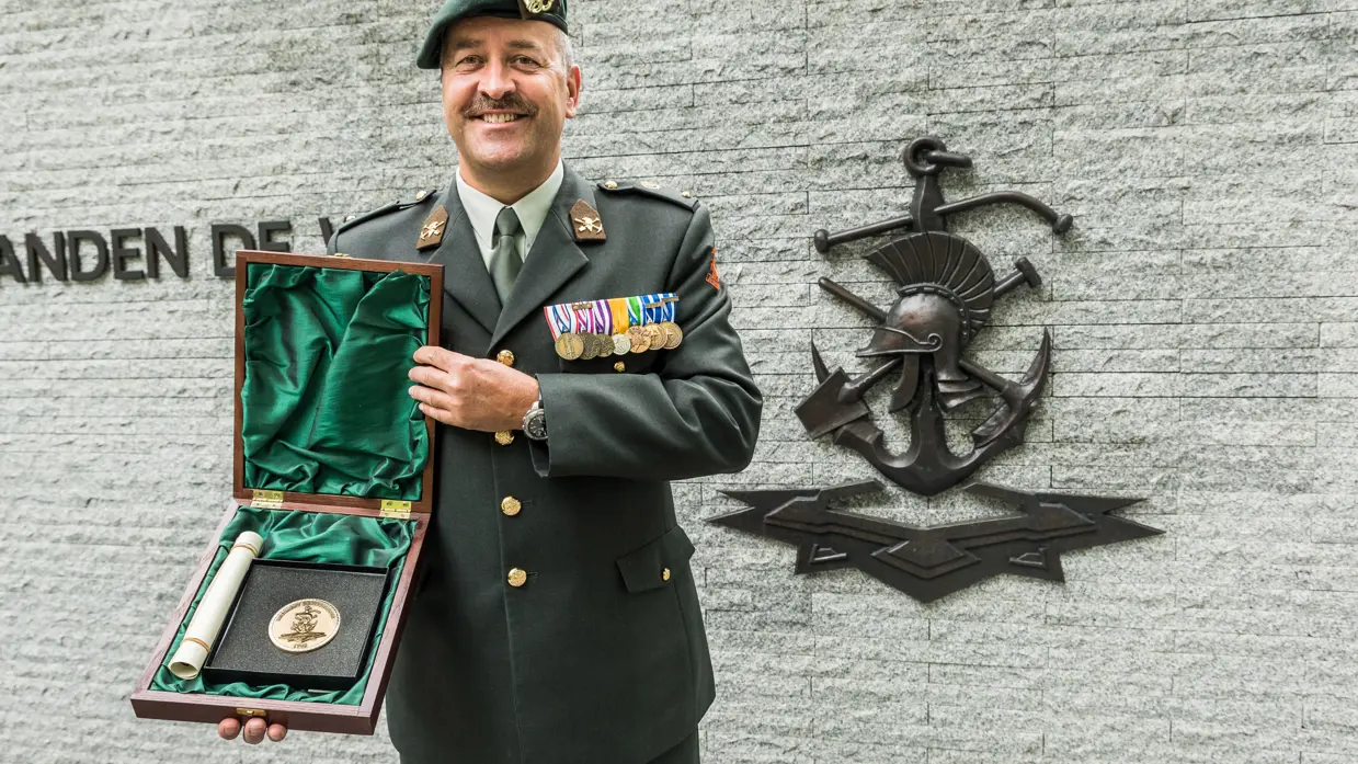 Militair toont Regimentslegpenning.