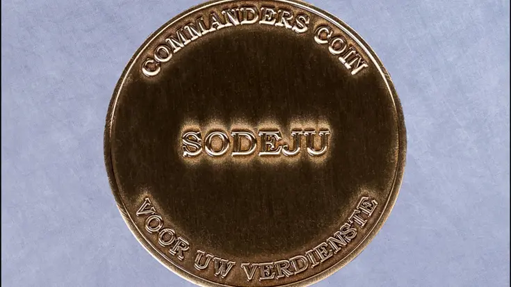 Een munt met tekst: commanders coin, sodeju, voor uw verdienste.