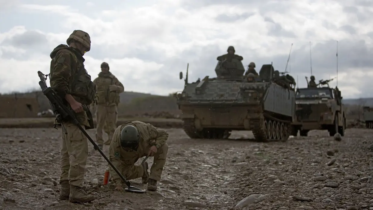 Militairen zoeken bermbommen in Afghanistan, 2008.