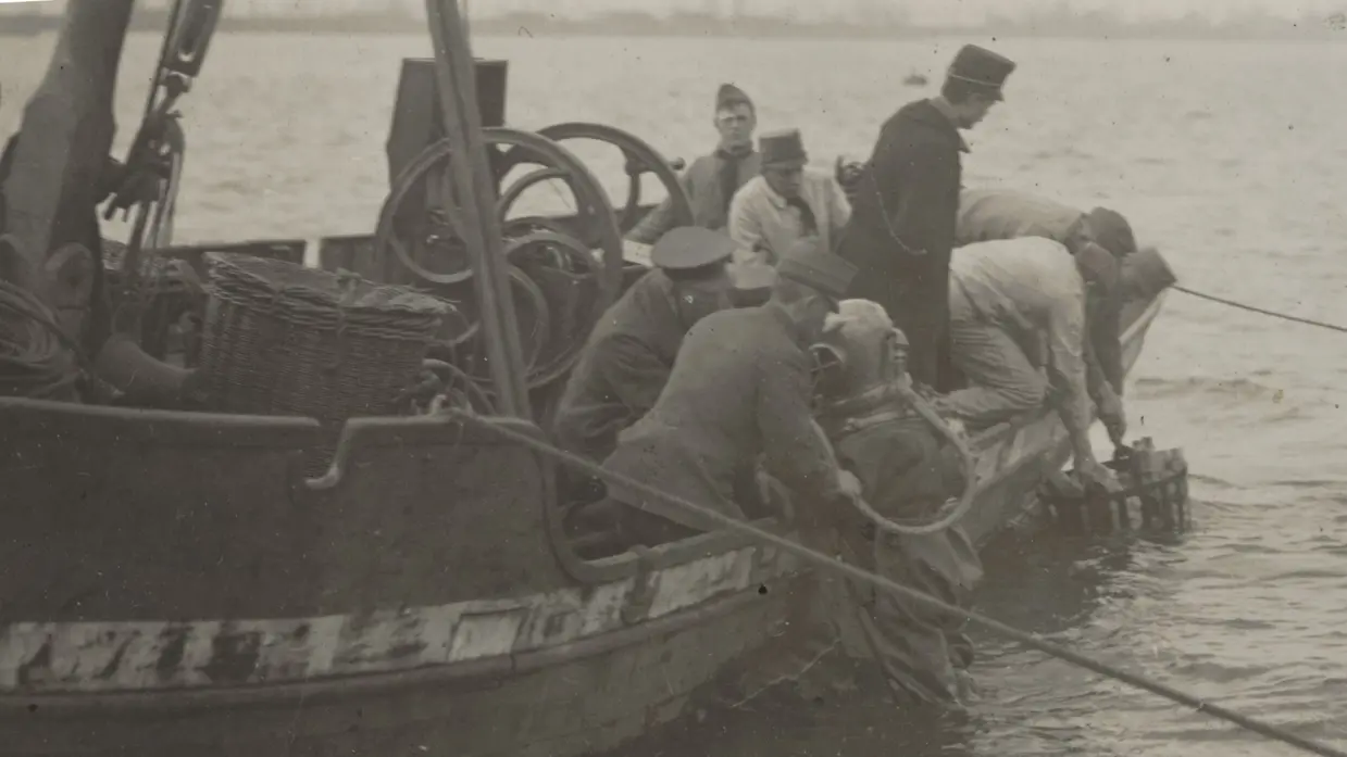 Genieduiker wordt op een boot geholpen op de Merwede, 1920.