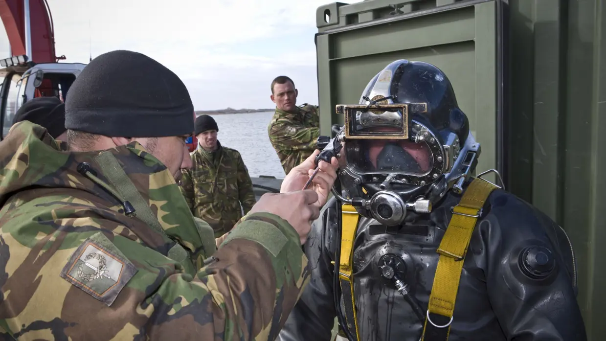 Een duiker wordt door een militair klaargemaakt om te duiken.