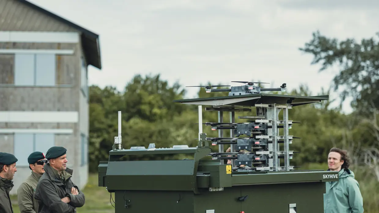 De bovenkant van het SkyHive-systeem van een andere hoek, met de hoofden van militairen links zichtbaar.