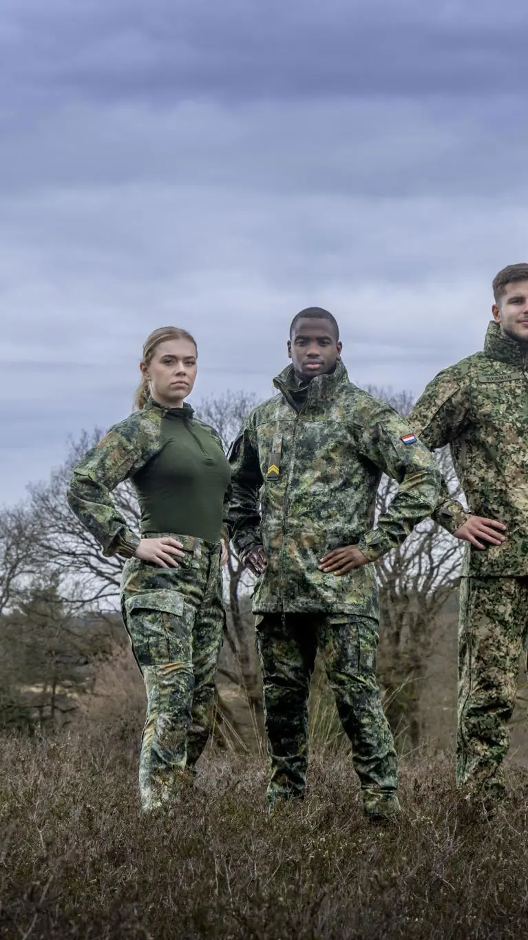 Vier militairen staan in het veld.
