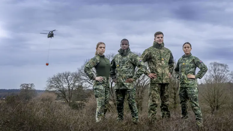 Vier militairen staan in het veld.