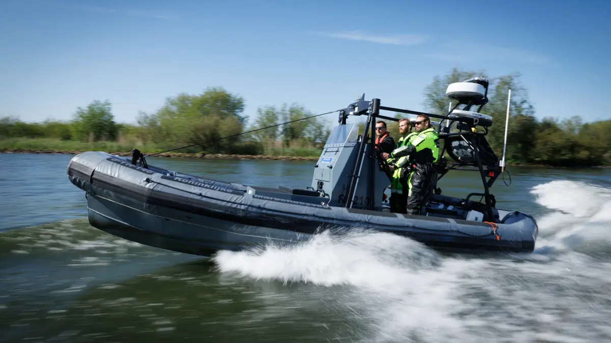 3 man staan op een rubberenboot van de marechaussee
