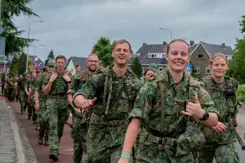 Vrolijke militairen lopen de vierdaagse.