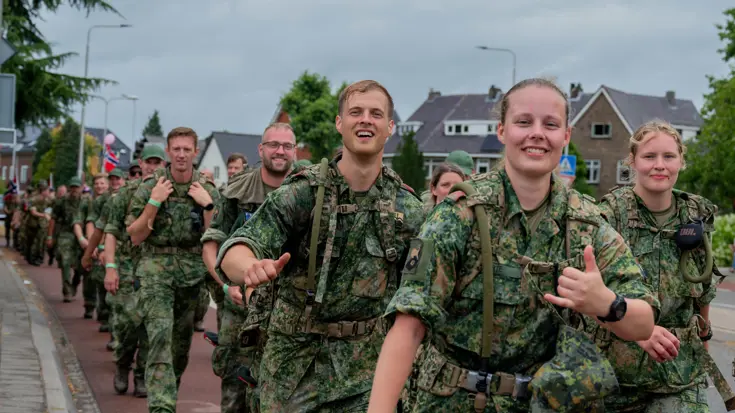 Vrolijke militairen lopen de vierdaagse.