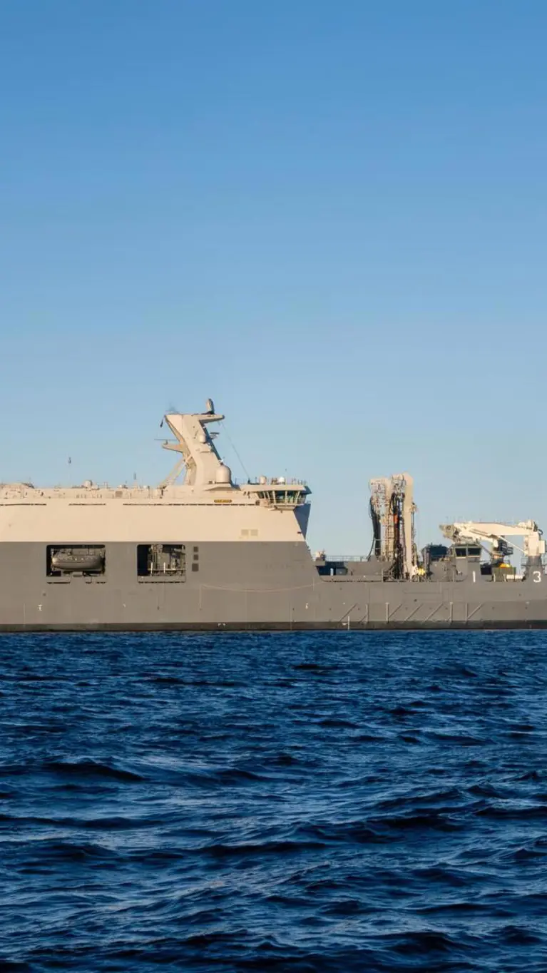 Het grijskleurige marineschip Zr.Ms. Den Helder dobbert op zee. 