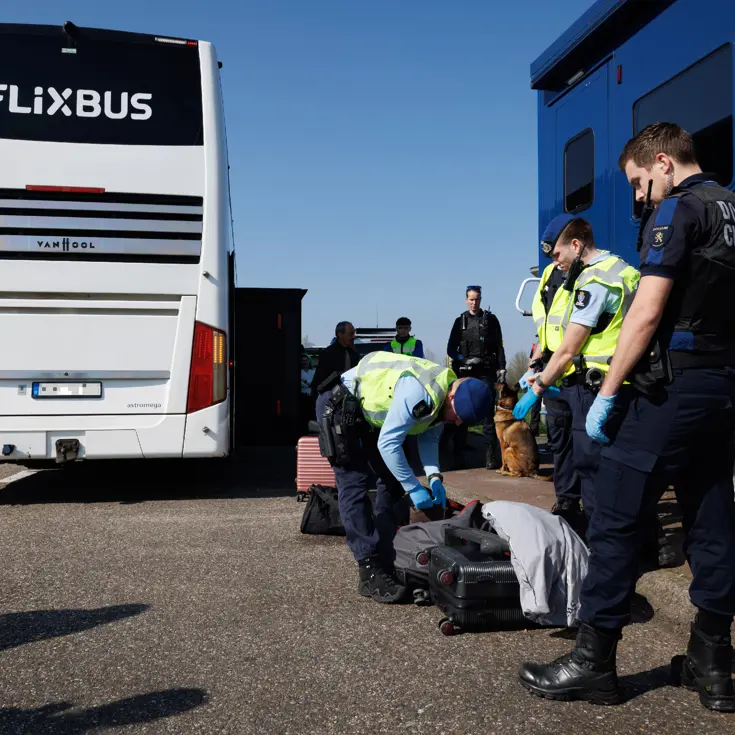 Marechaussees zijn bezig met een controle, op de achtergrond een Flixbus.