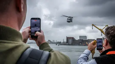 Een helikopter vliegt boven het water.