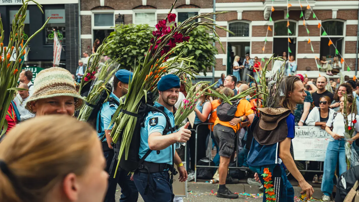 Twee marechaussees met een bos gladiolen op de rug, bij de finish van de Nijmeegse 4Daagse.