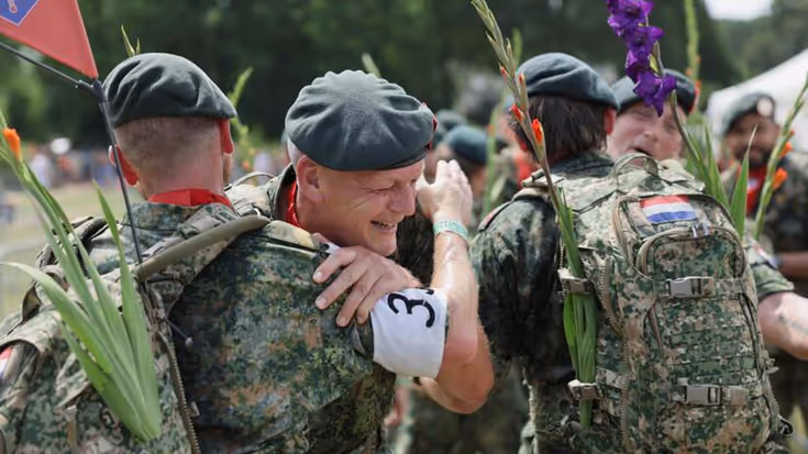 Militairen feliciteren elkaar na uitlopen Nijmeegse Vierdaagse. 