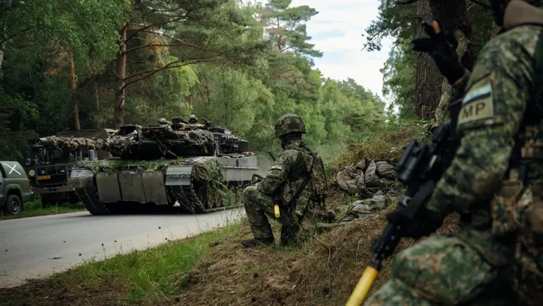 Marechaussees van 103 Marechaussee Eskadron met op de achtergrond een voertuig van de Landmacht.