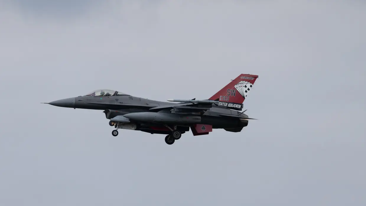 Een F-16 in de landing onder een blauwe lucht. 