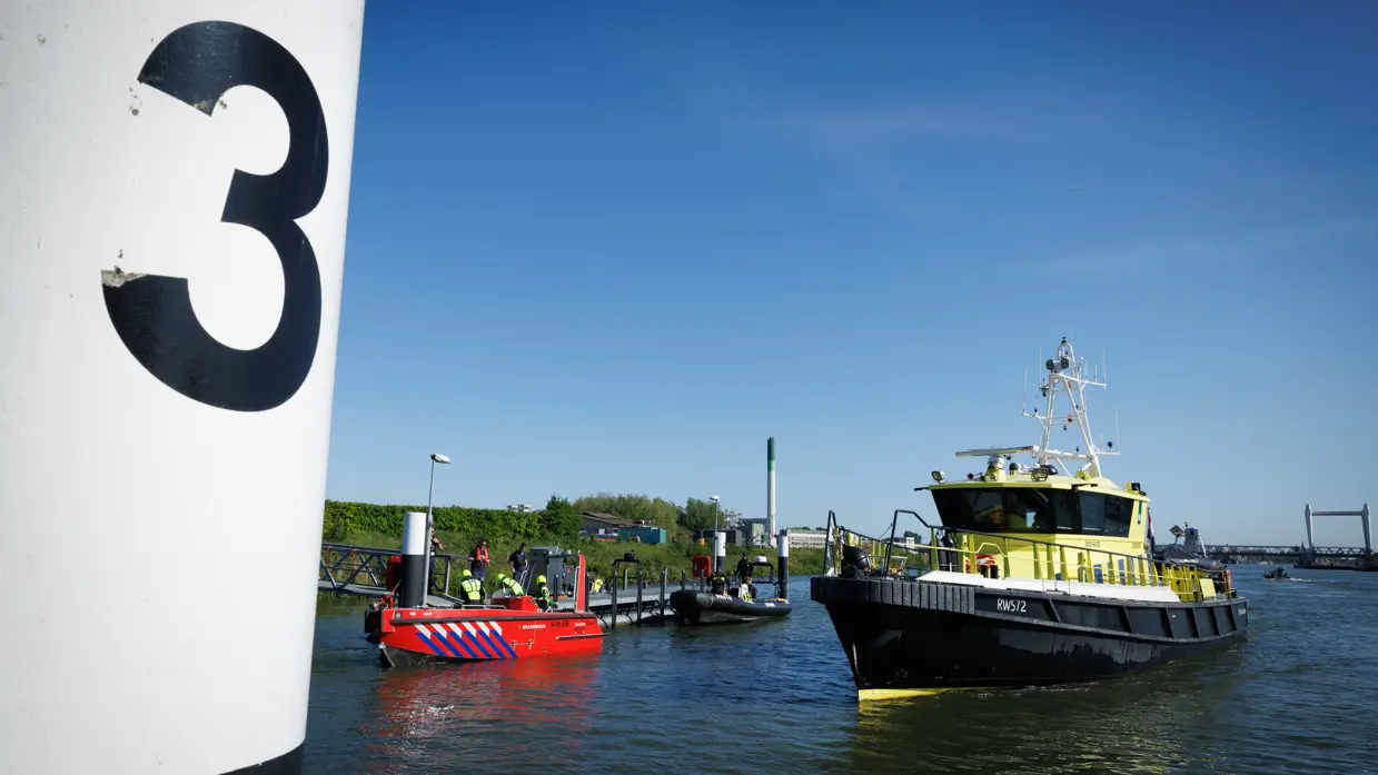 Vaartuigen van de brandweer en Rijkswaterstaat op het water. 