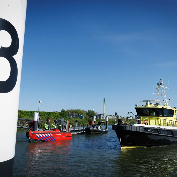 Vaartuigen van de brandweer en Rijkswaterstaat op het water. 