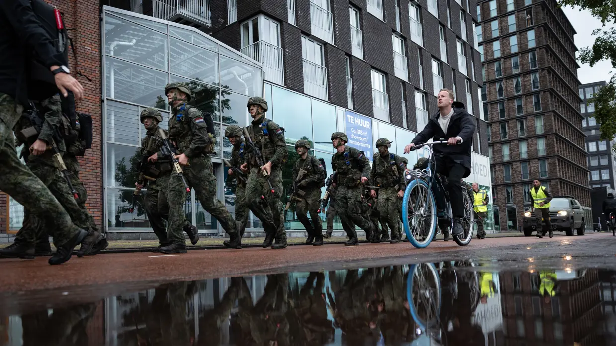De deelnemers aan de NWT marcheren door Amsterdam.
