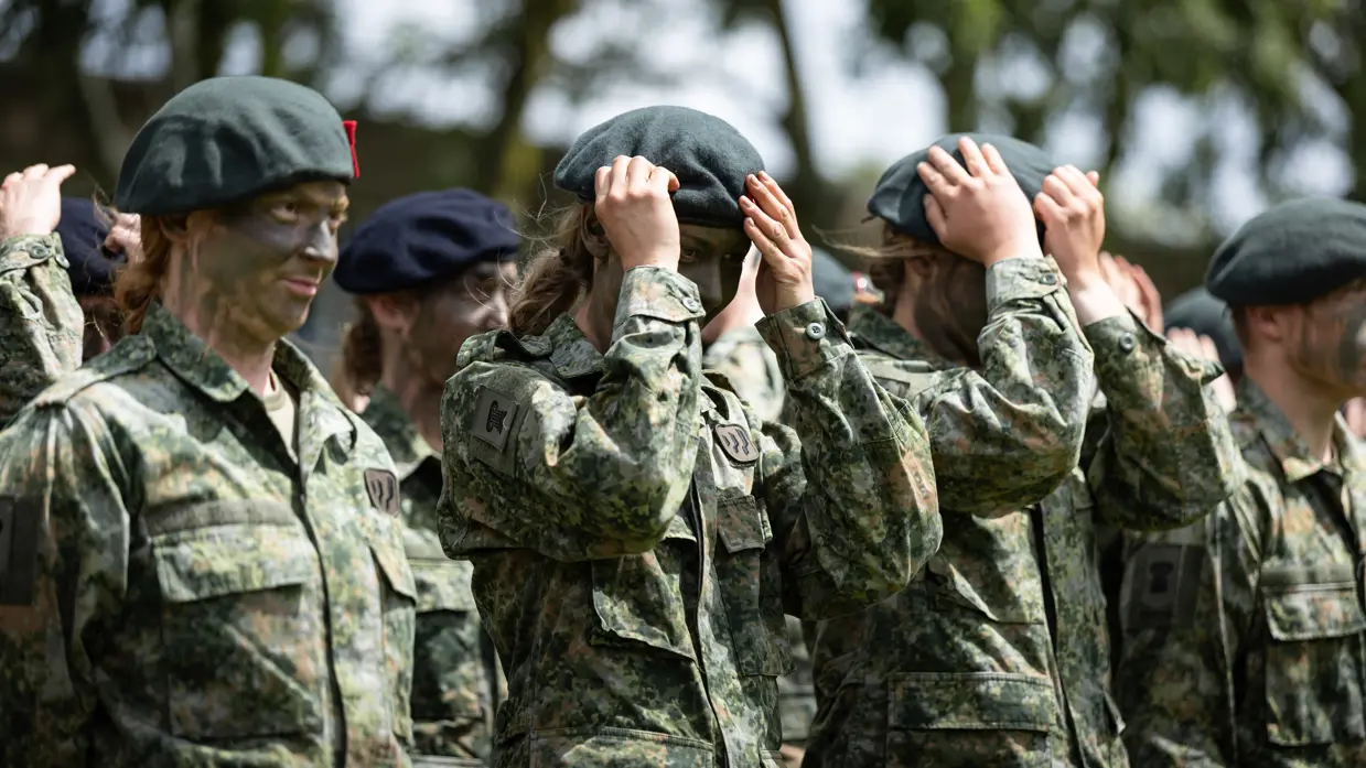 Militairen zetten hun baretten op.