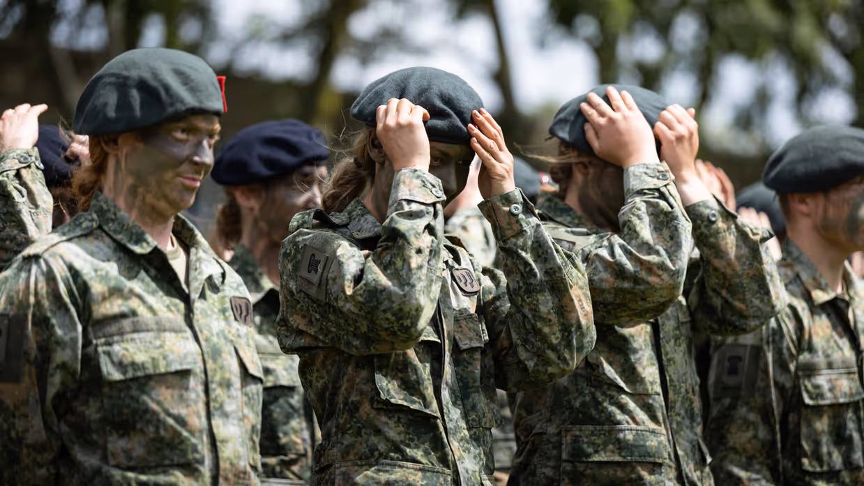 Militairen zetten hun baretten op.
