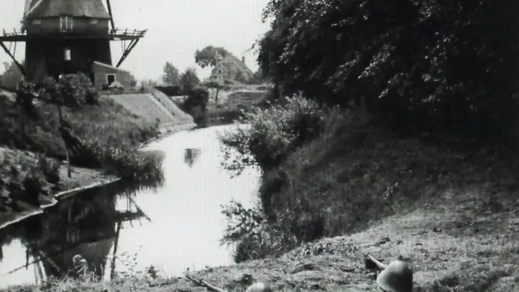 Militairen Vrijwillige Landstorm in dekking bij molen.
