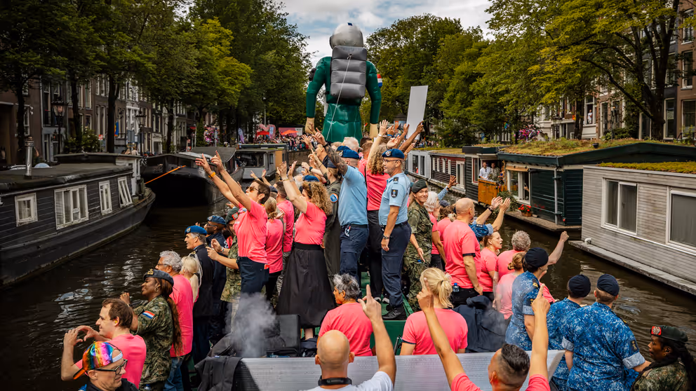 De defensieboot vaart door een Amsterdamse gracht. 