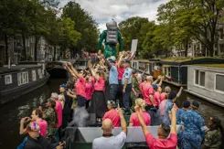 De defensieboot vaart door een Amsterdamse gracht. 