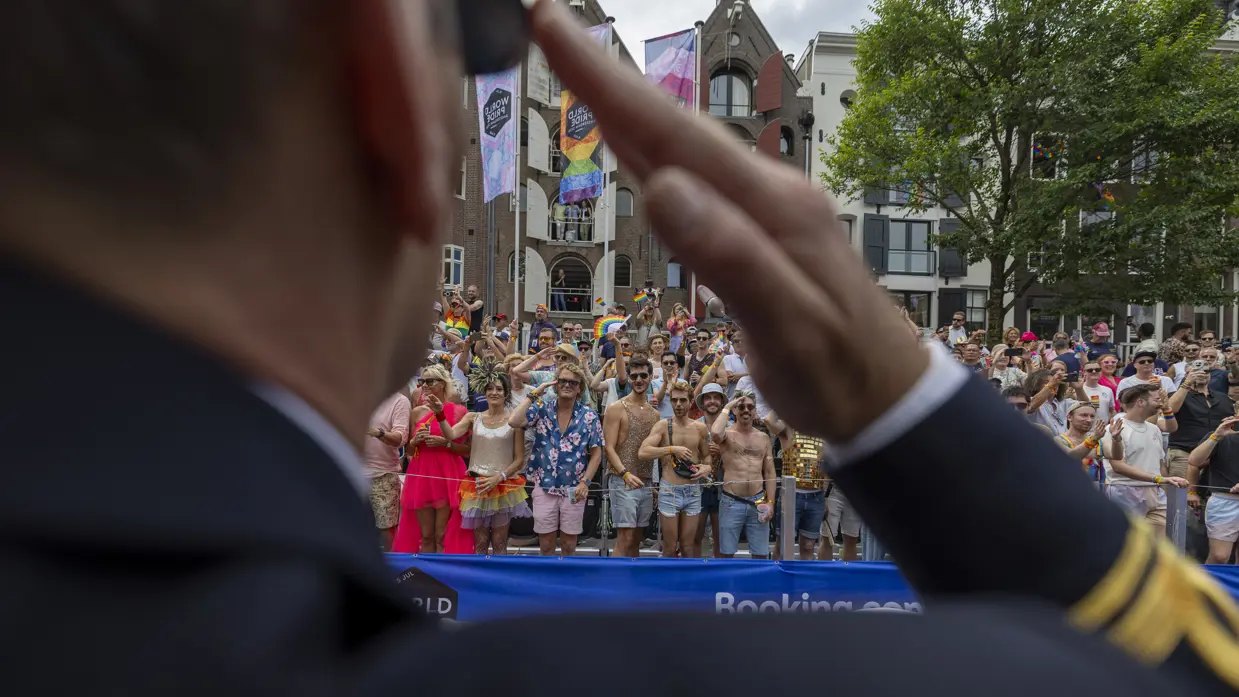 Een militair salueert naar mensen aan de kant van de gracht.