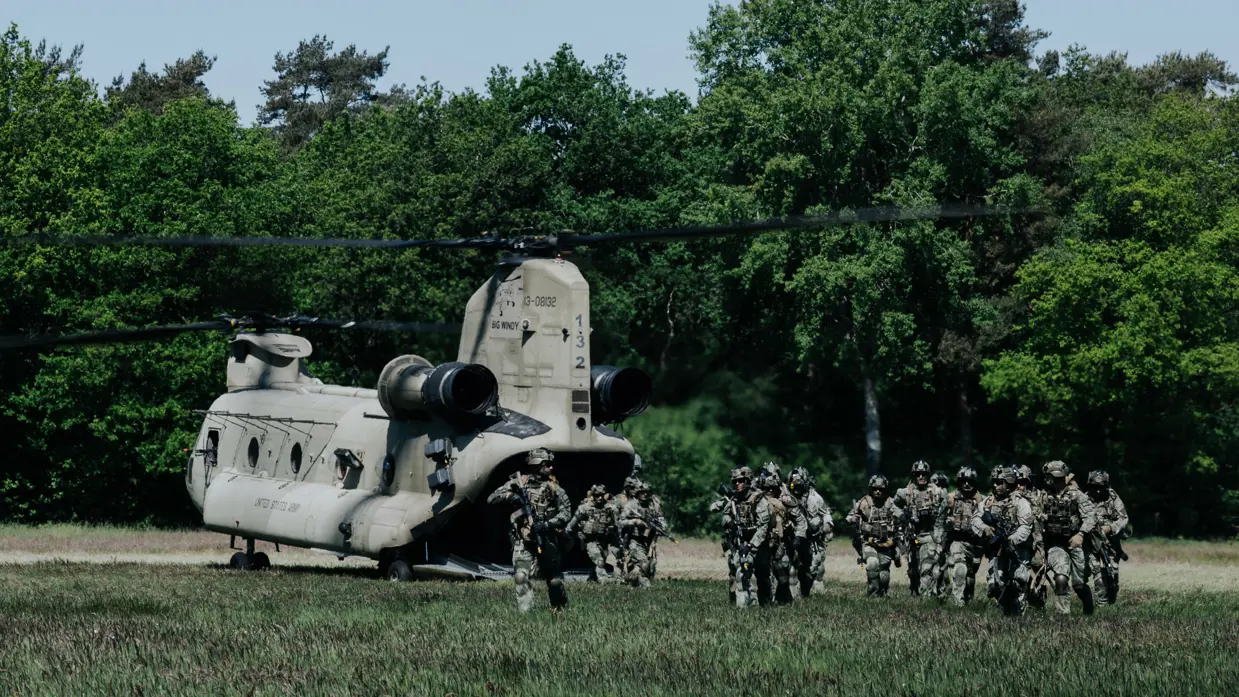 Een groepje militairen stapt uit een Chinook-transporthelikopter.
