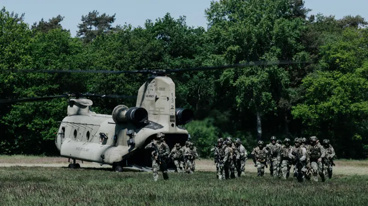 Een groepje militairen stapt uit een Chinook-transporthelikopter.