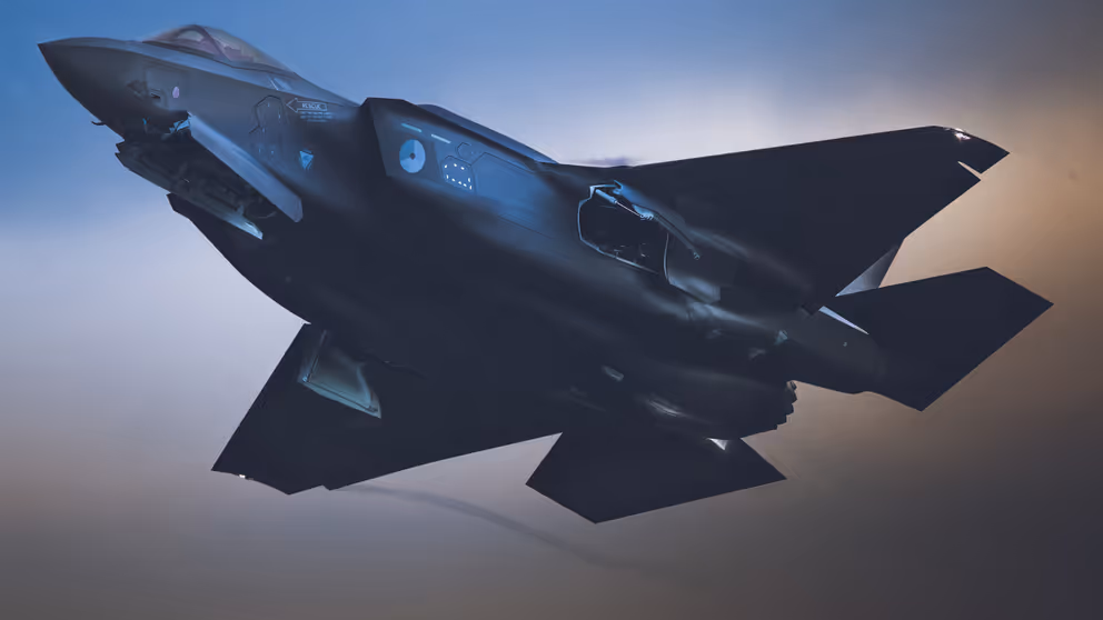 Een F-35 vliegt in de schemering.