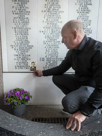 Dirk bij het KNSM-monument met een foto van zijn opa.