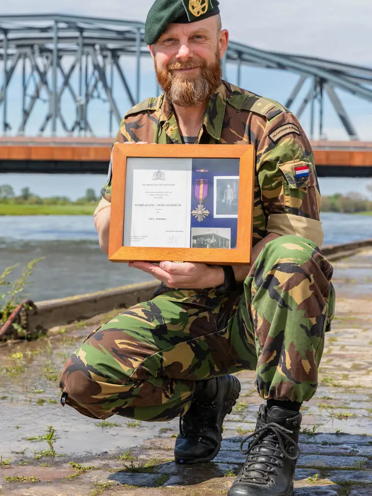 Militair voor de Oude IJsselbrug met mobilisatiekruis van zijn opa.