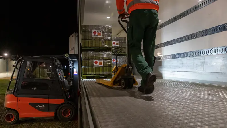 Personeel haalt pallets uit een vrachtwagen