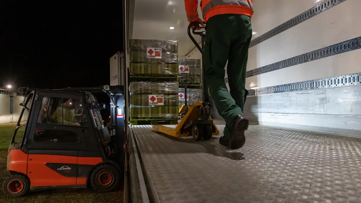 Personeel haalt pallets uit een vrachtwagen