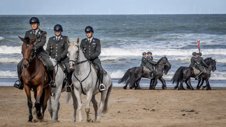 Militairen te paard tijdens het oefenen voor Prinsjesdag op het strand.