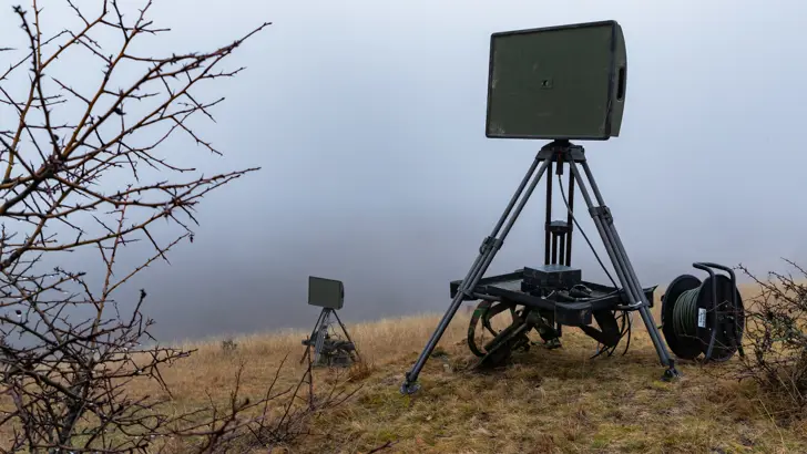 Een radar staat op een heuvel met mist op de achtergrond.