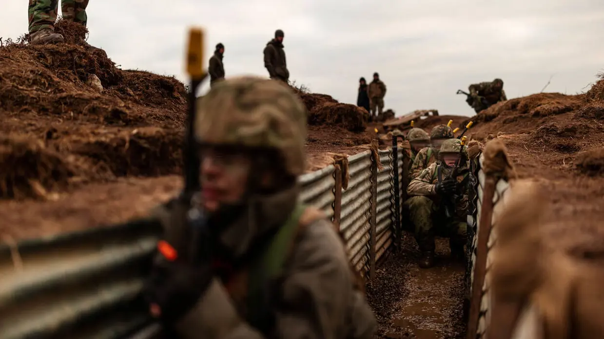 Militairen trainen in een loopgraaf.