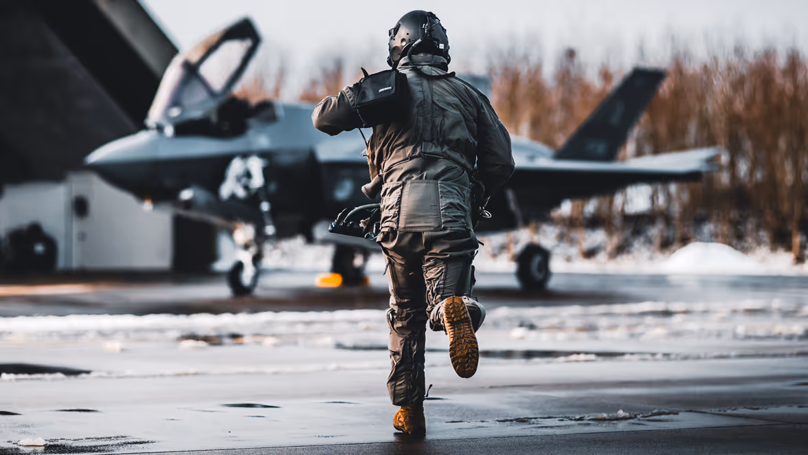 Rennende militair naar een gevechtsvliegtuig.