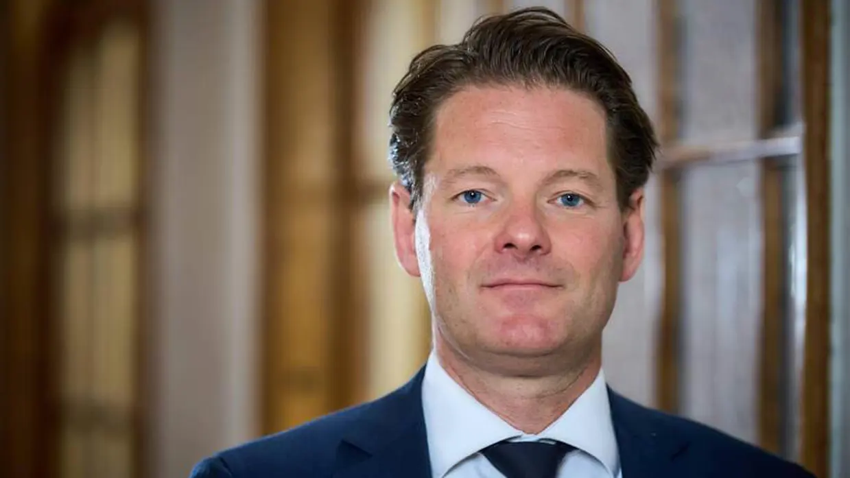 Portret vanaf de schouders van secretaris-generaal Maarten Schurink. De SG draagt een blauw pak en kijkt recht in de camera.