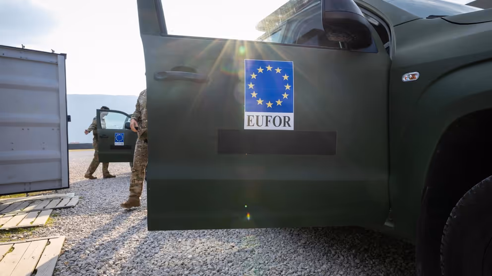Openstaand portier van militair voertuig. Op portier staat EU-logo en daaronder EUFOR.
