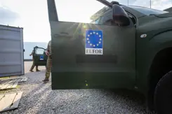 Openstaand portier van militair voertuig. Op portier staat EU-logo en daaronder EUFOR.