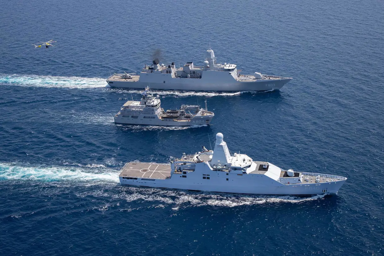 2 marineschepen op zee met in het midden een kustwachtvaartuig.