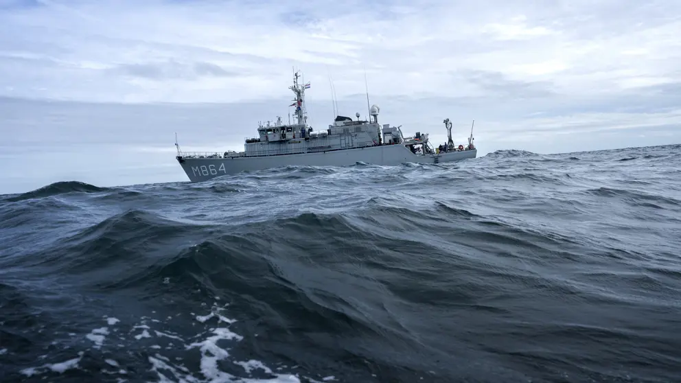 Marineschip vaart door woeste golven.