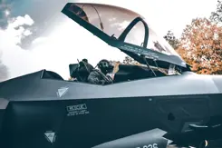 Pilot in F-35 met cockpit open.