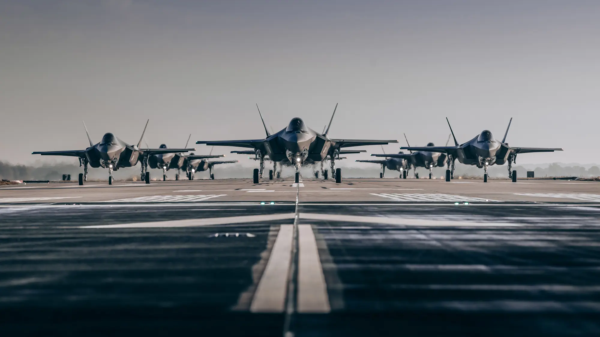 Meerdere F-35-gevechtsvliegtuigen opgesteld op startbaan.
